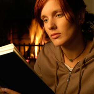 mujer-leyendo-concentrada-frente-a-la-chimenea